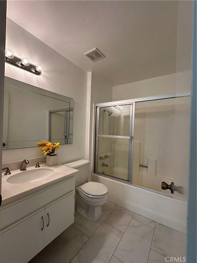 full bathroom with toilet, enclosed tub / shower combo, vanity, and a textured ceiling