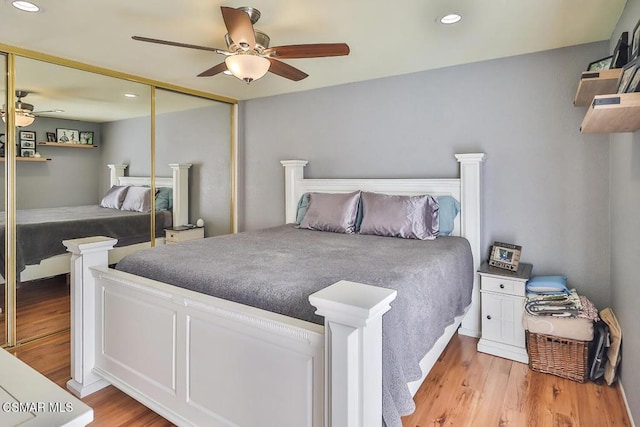 bedroom with light hardwood / wood-style flooring, a closet, and ceiling fan