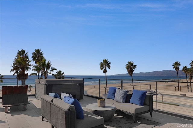 view of patio featuring a water and mountain view, a balcony, and an outdoor hangout area