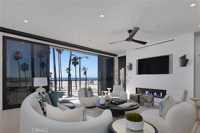 living room featuring ceiling fan, floor to ceiling windows, and light hardwood / wood-style floors