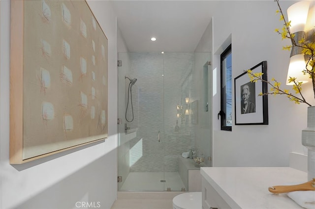 bathroom featuring vanity, toilet, and an enclosed shower