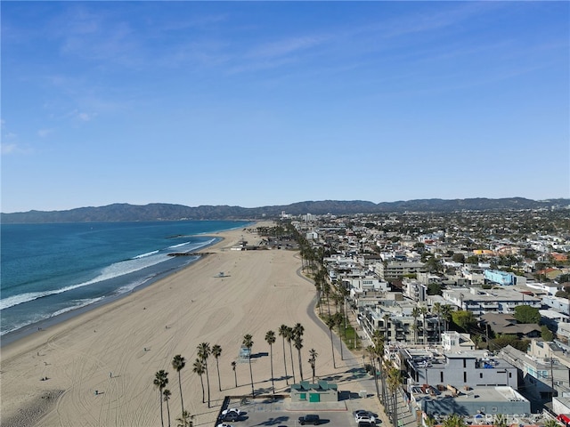 drone / aerial view featuring a water and mountain view and a view of the beach