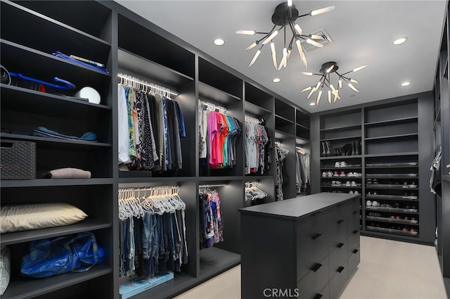 walk in closet featuring a notable chandelier