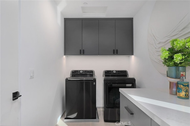 laundry room featuring cabinets and washer and clothes dryer