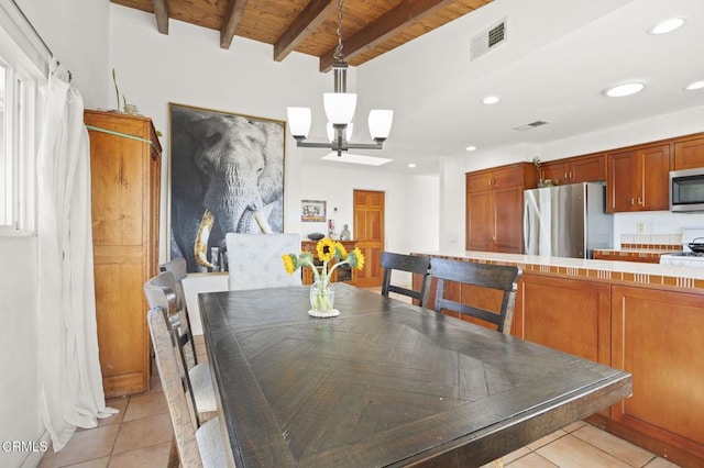 dining room with beamed ceiling, a skylight, light tile patterned flooring, and wooden ceiling