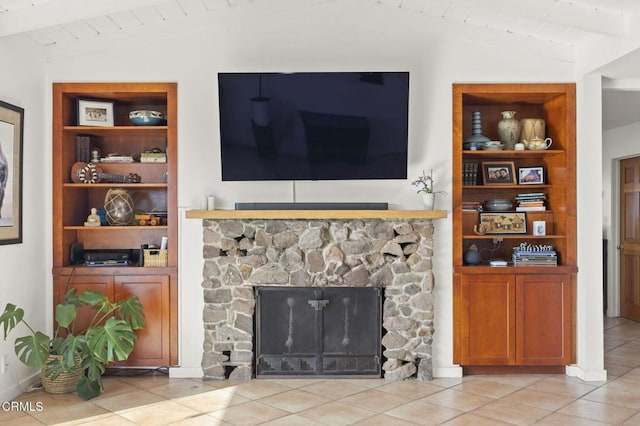 tiled living room with built in features, a stone fireplace, vaulted ceiling with beams, and wooden ceiling