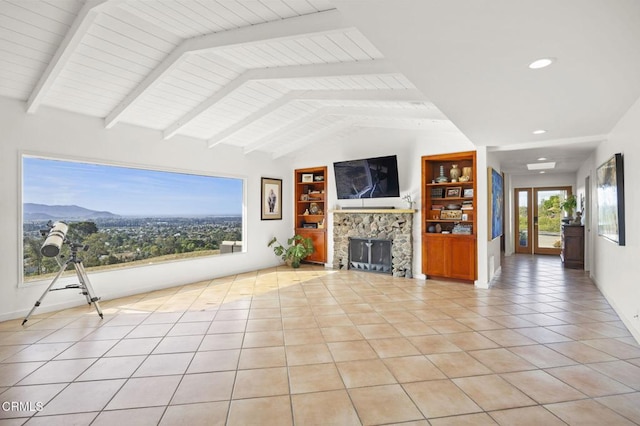 unfurnished living room with built in shelves, vaulted ceiling with beams, light tile patterned floors, a mountain view, and a fireplace