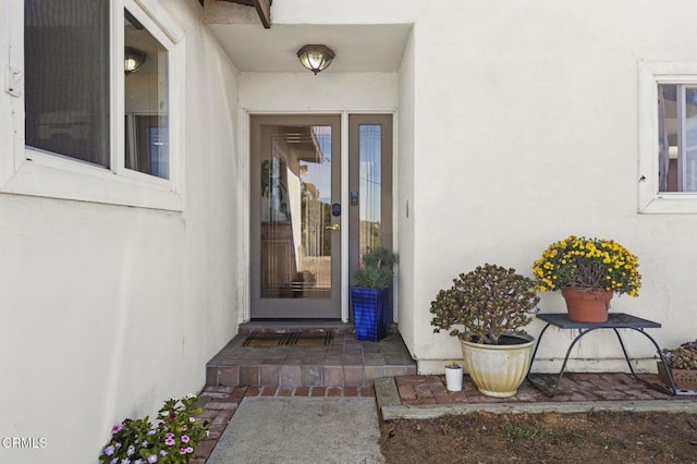 entrance to property featuring stucco siding