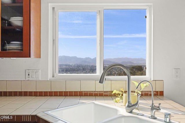 interior details featuring glass insert cabinets, a mountain view, and a sink