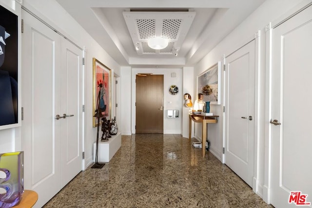 hall featuring a tray ceiling