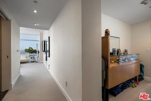 hallway featuring light colored carpet