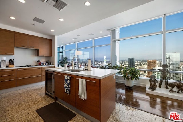 kitchen featuring an island with sink, wine cooler, gas cooktop, and sink