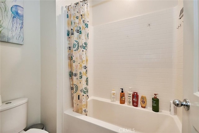 bathroom featuring shower / bath combination with curtain and toilet