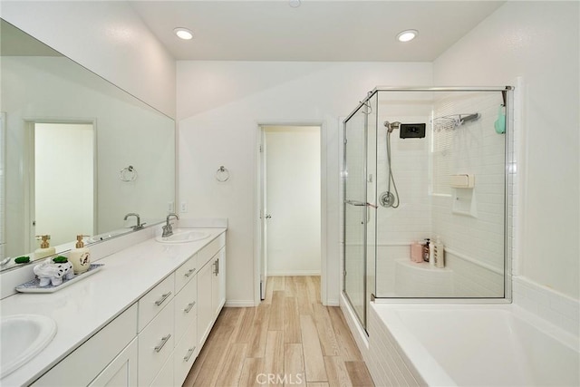 bathroom featuring wood-type flooring, shower with separate bathtub, and vanity