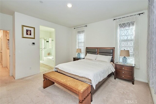 bedroom with light carpet and ensuite bathroom