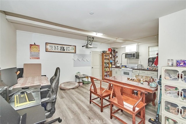 interior space with white cabinets, white gas range oven, and light hardwood / wood-style floors