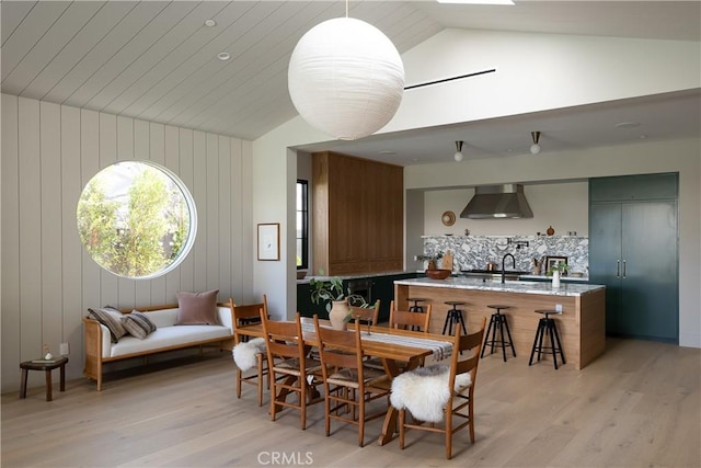 dining area with lofted ceiling, light wood-type flooring, and sink