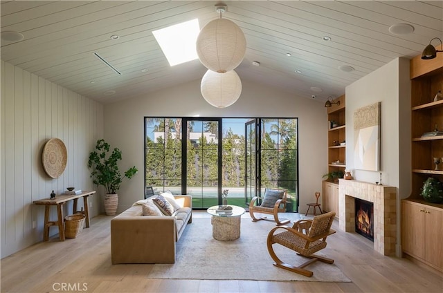 living room featuring built in shelves, vaulted ceiling, wood walls, and light wood-type flooring