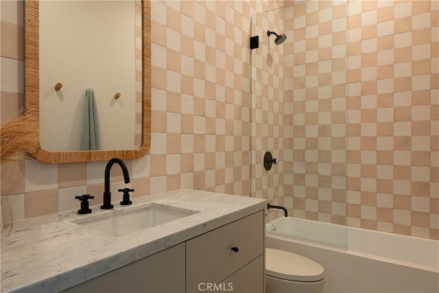 full bathroom featuring toilet, tiled shower / bath, and vanity