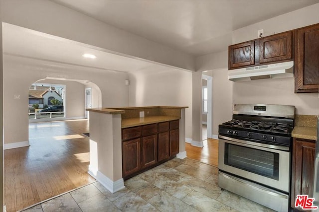 kitchen featuring a healthy amount of sunlight, gas range, and dark brown cabinetry