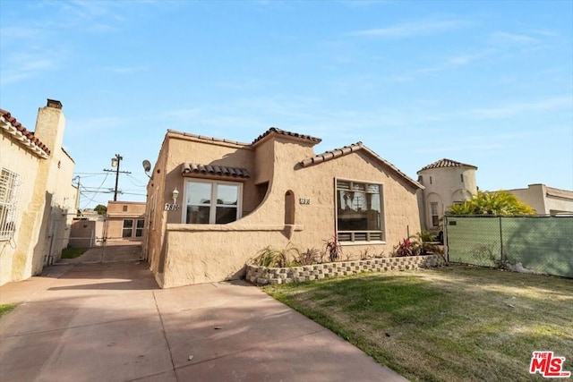 mediterranean / spanish house featuring a front yard