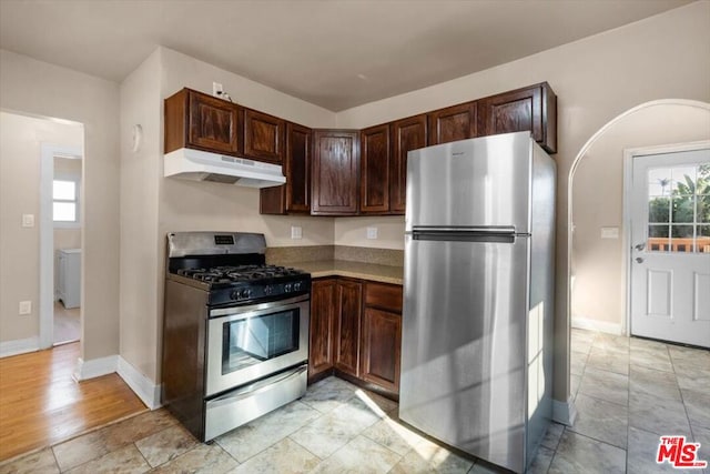 kitchen with dark brown cabinetry and appliances with stainless steel finishes