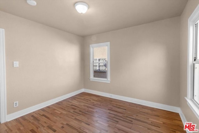 unfurnished room with a healthy amount of sunlight and wood-type flooring