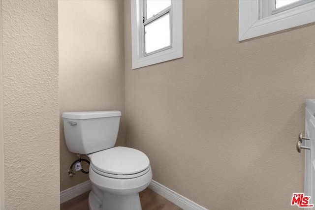 bathroom with toilet and wood-type flooring