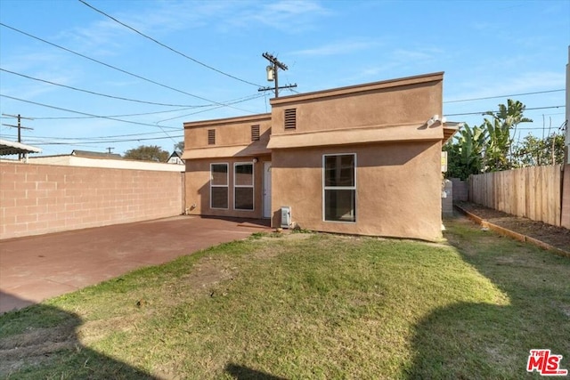 back of house featuring a patio and a yard