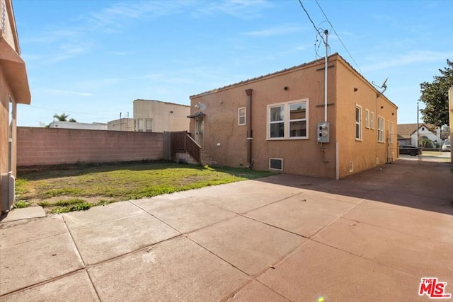 back of property featuring a lawn and a patio