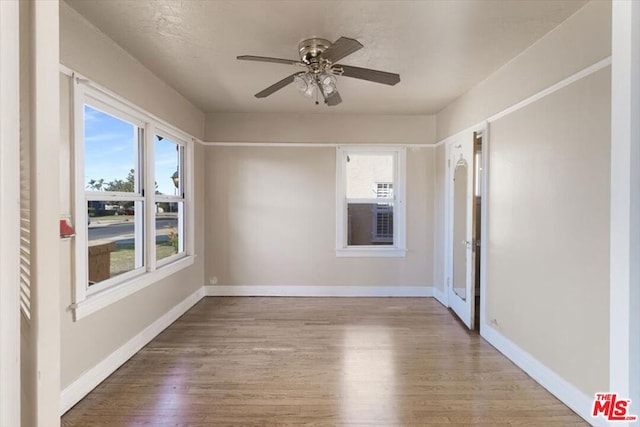 unfurnished room with ceiling fan, plenty of natural light, and light hardwood / wood-style flooring