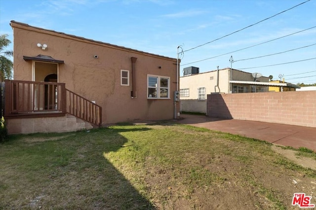 rear view of house featuring a patio area and a yard