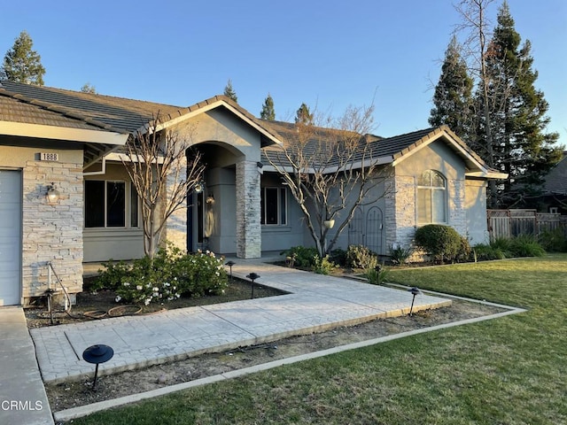 view of front of home featuring a garage and a front lawn