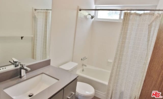 full bathroom featuring toilet, vanity, and shower / bath combo with shower curtain