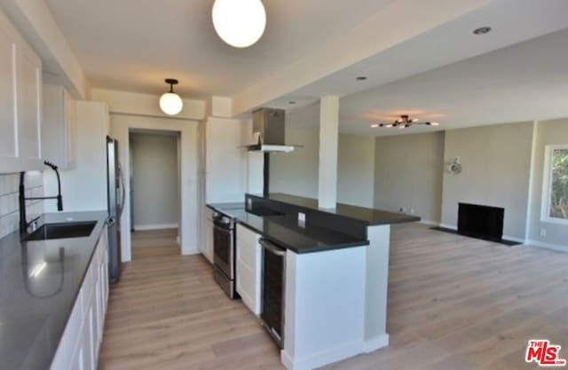 kitchen with white cabinets, sink, stainless steel appliances, and light hardwood / wood-style floors