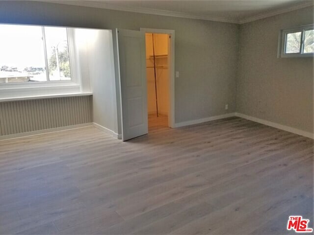 unfurnished room with crown molding and hardwood / wood-style floors