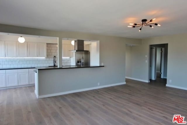 kitchen featuring stainless steel fridge with ice dispenser, white cabinetry, backsplash, and hardwood / wood-style floors