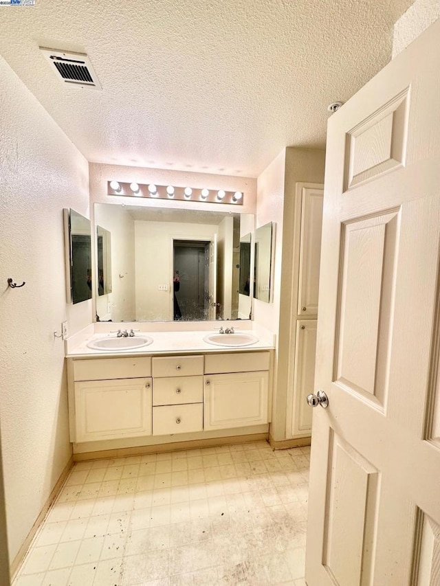 bathroom with vanity and a textured ceiling