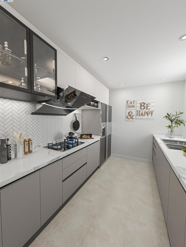 kitchen featuring sink, gray cabinetry, gas stovetop, ventilation hood, and decorative backsplash