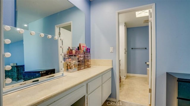 bathroom with tile patterned floors, baseboards, and vanity