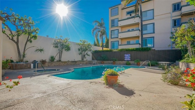 view of pool featuring a community hot tub and a patio