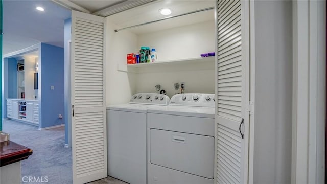 clothes washing area featuring light carpet, laundry area, and washing machine and clothes dryer