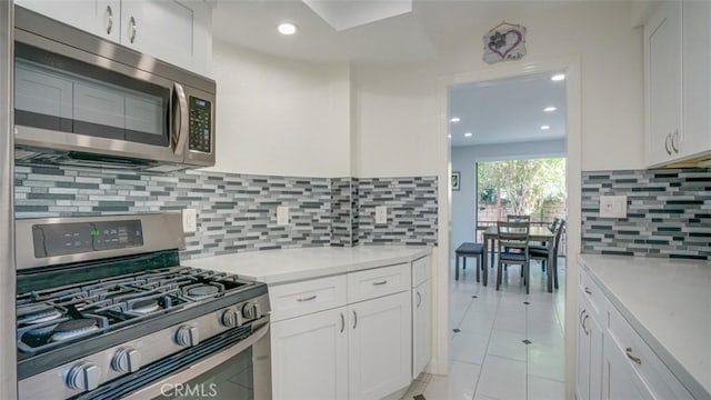 kitchen with stainless steel appliances, light countertops, and white cabinets