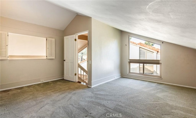 bonus room with vaulted ceiling and carpet flooring