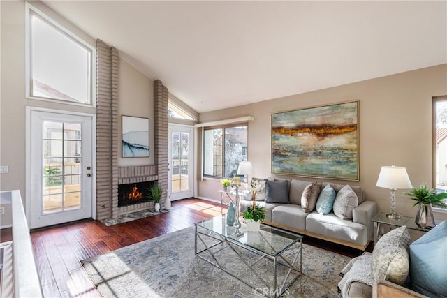 living room featuring lofted ceiling, dark hardwood / wood-style floors, and a fireplace