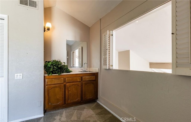 corridor with vaulted ceiling, sink, and light colored carpet