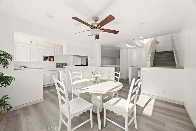 dining space featuring light wood-type flooring and ceiling fan