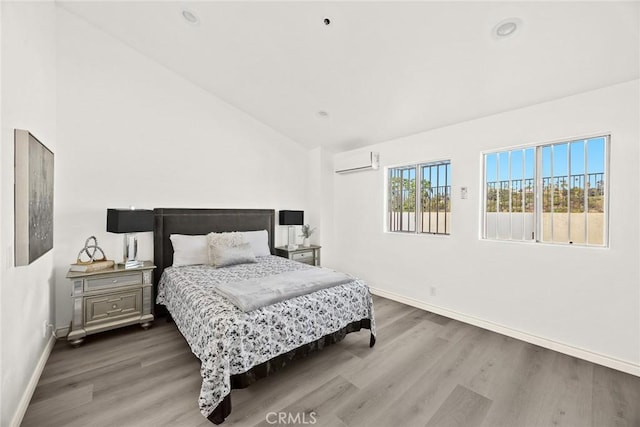 bedroom with high vaulted ceiling, an AC wall unit, and hardwood / wood-style floors