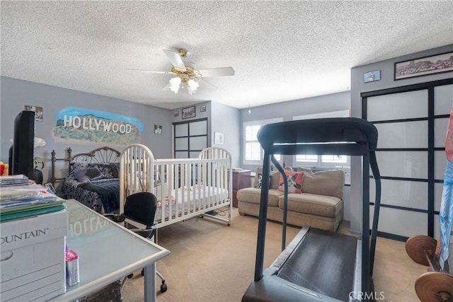 carpeted bedroom with ceiling fan and a textured ceiling