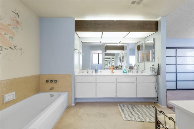 bathroom featuring beam ceiling, vanity, and a bathtub